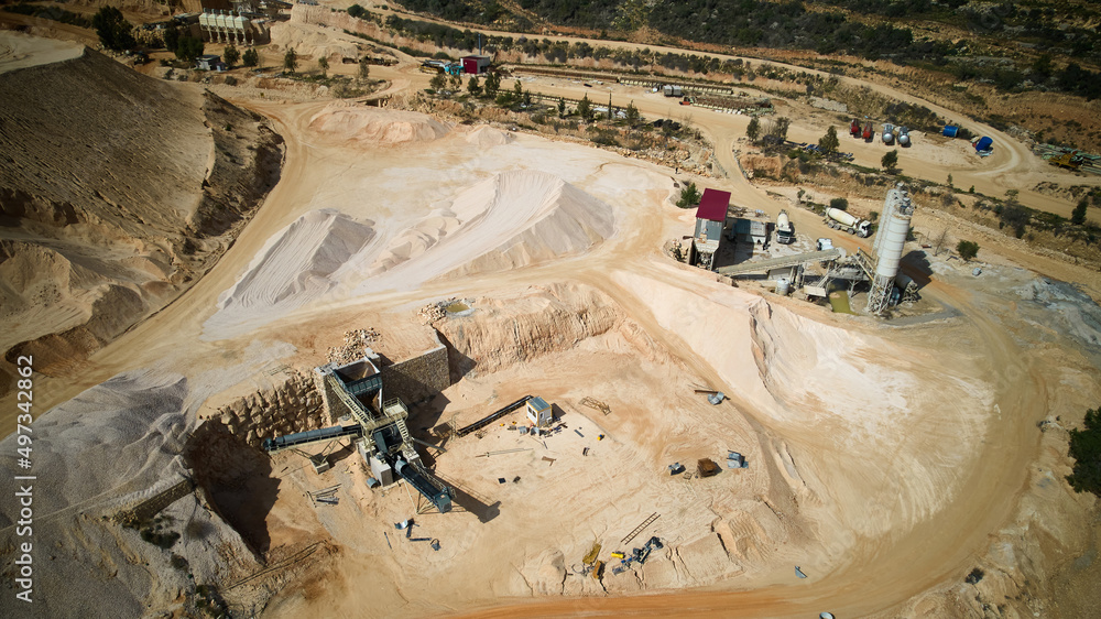Aerial view of crushed stone quarry machine. Producing of construction materials at open pit limestone mine. Stone crushing plant. Cone type rock crusher