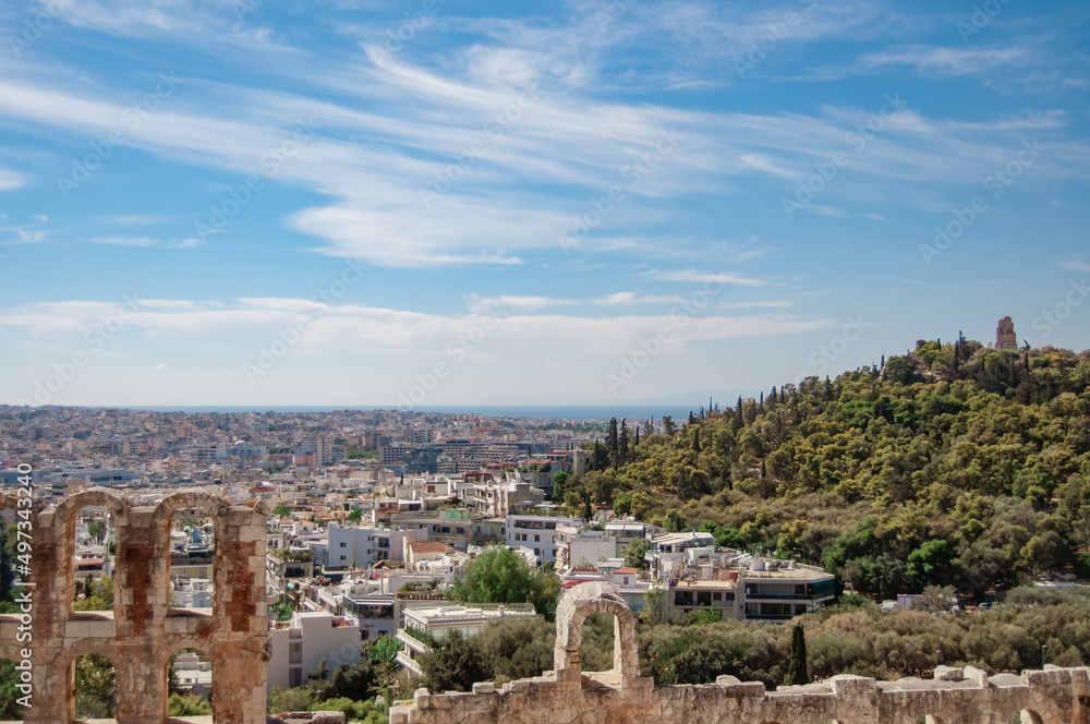 View of the ancient building Odeon of Herodes and the houses of the city of Athens, Greece.