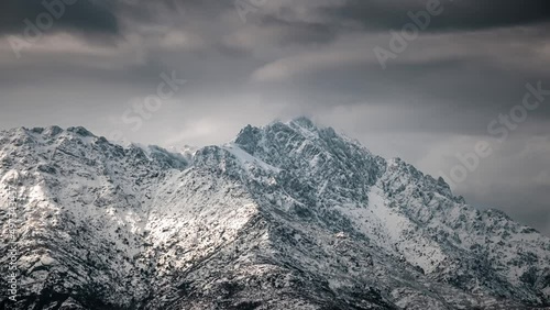 Time lapse of dark clouds over a snow capped Monte Grosso in the Balagne region of Corsica photo