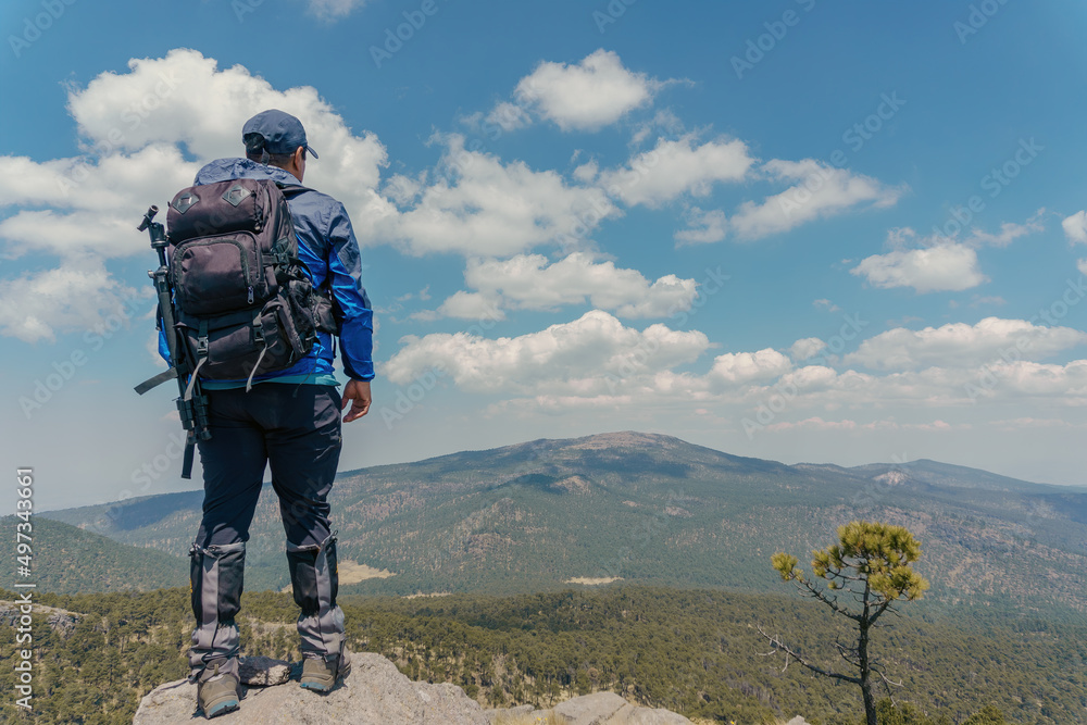 Person standing on rock with mountain viewpoint