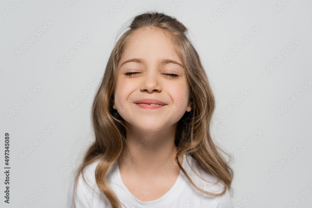 portrait of pleased girl with closed eyes isolated on grey. portrait of pleased girl with closed eyes isolated on grey.