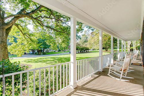 Southern country living covered front porch summer spring day tree sunlight warm sunshine white rocking chairs