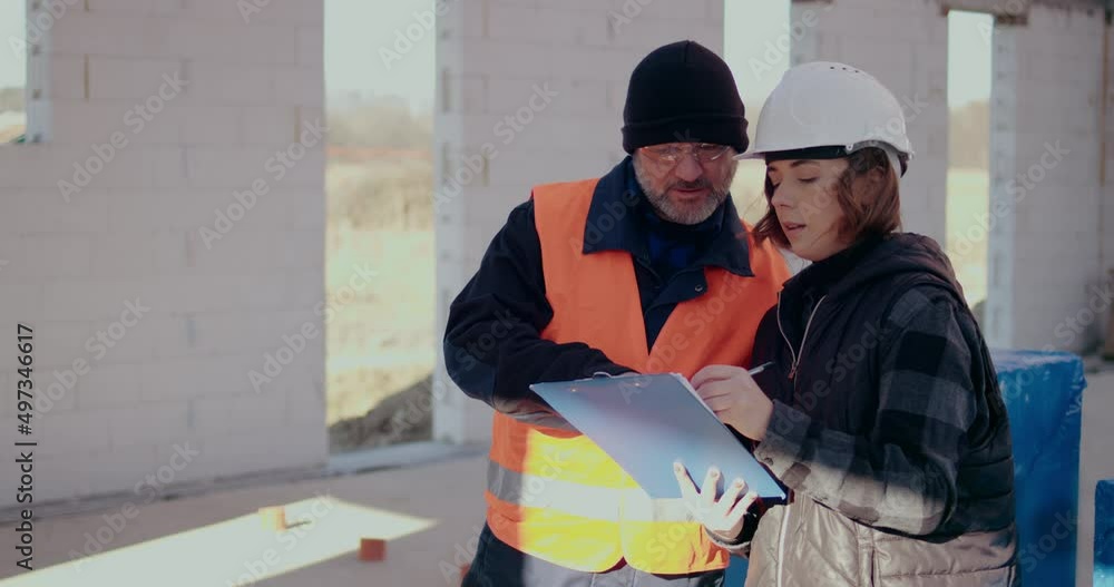 Concentrated Engineers discussing, examining and developing at Construction Site Concentrated Engineers discussing, examining and developing at Construction Site