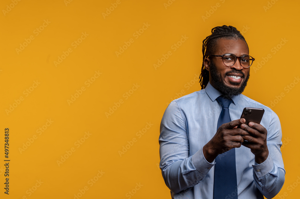 Stylish entrepreneur with the smartphone standing by the wall Stylish entrepreneur with the smartphone standing by the wall