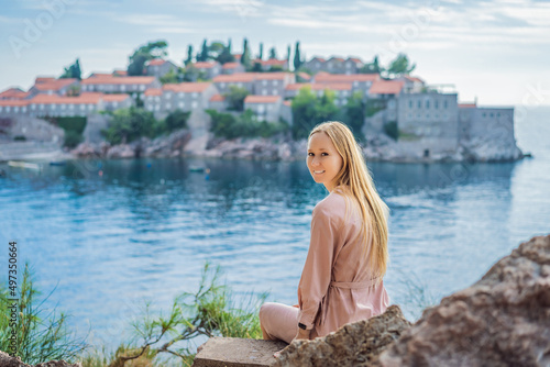 Woman tourist on background of beautiful view of the island of St. Stephen, Sveti Stefan on the Budva Riviera, Budva, Montenegro. Travel to Montenegro concept © galitskaya