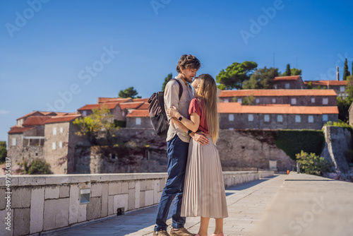 Man and woman tourists on background of beautiful view of the island of St. Stephen, Sveti Stefan on the Budva Riviera, Budva, Montenegro. Travel to Montenegro concept