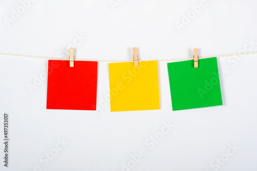 Tres post its con colores de semáforo de rojo a verde, colgados para ejercicio, estrategia o trabajo en equipo, conceptos a tratar.