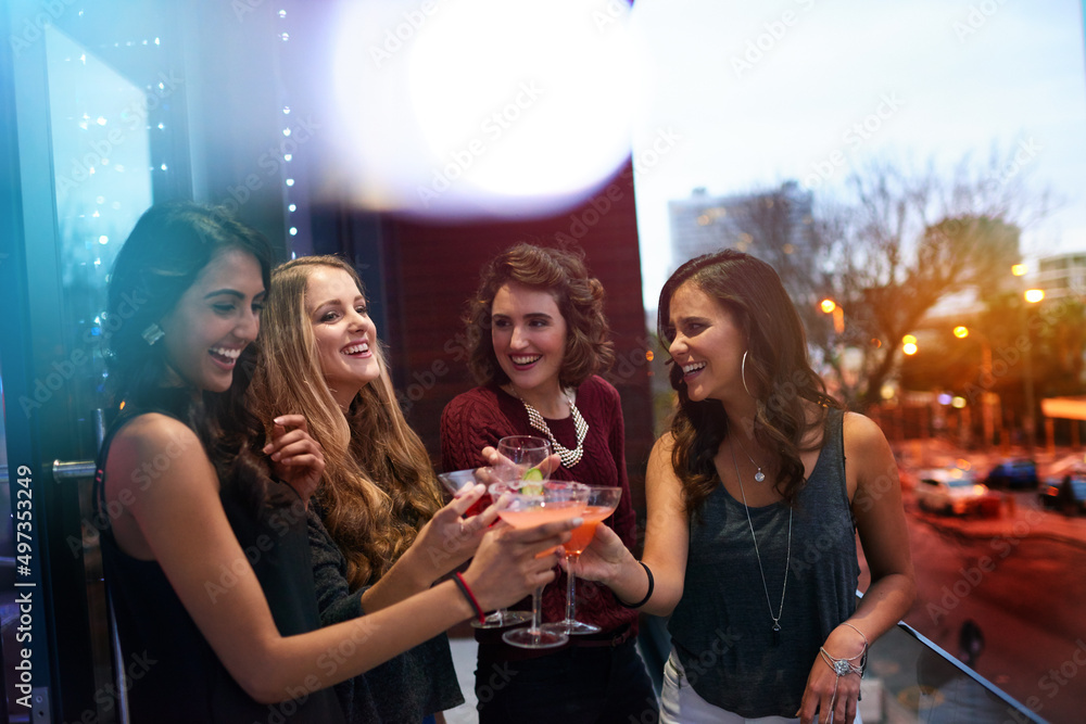 Grab your girls for a great night out. Shot of a group of young women drinking cocktails at a party.