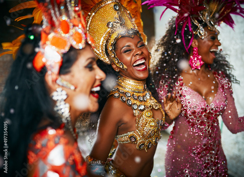 Theyre the best of friends. Cropped shot of three beautiful samba dancers performing in a carnival with their band.