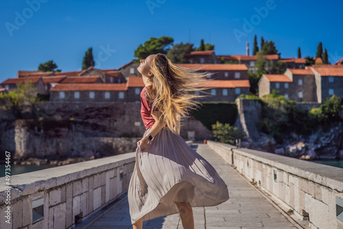 Woman tourist on background of beautiful view of the island of St. Stephen, Sveti Stefan on the Budva Riviera, Budva, Montenegro. Travel to Montenegro concept