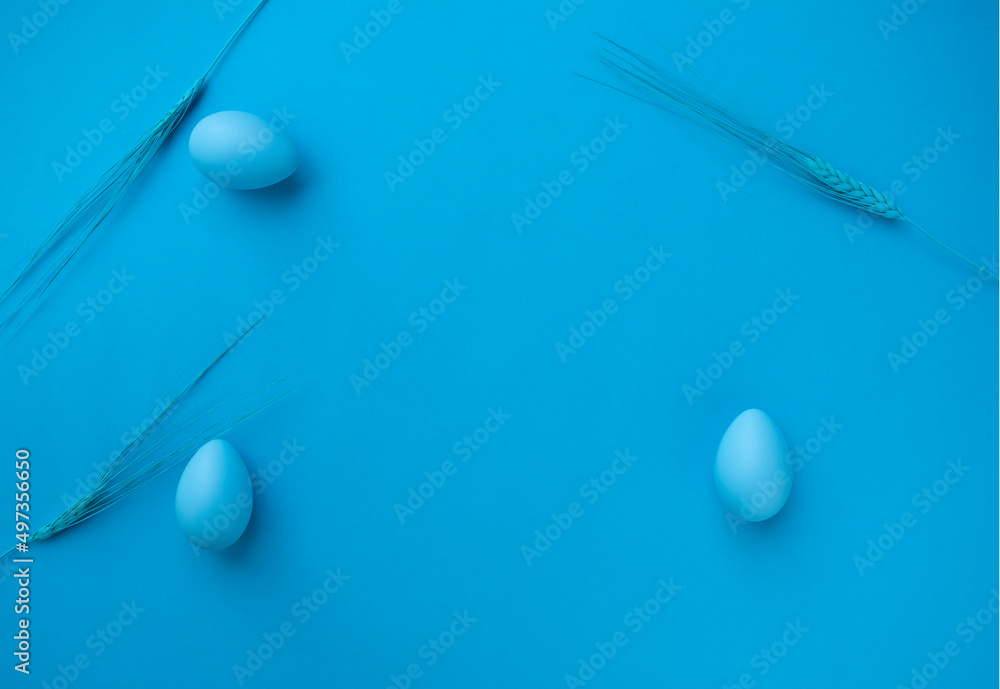 Fototapeta premium Eggs and Ears of wheat on blue background. Easter eggs. Healthy diet. Abstract. Copy space