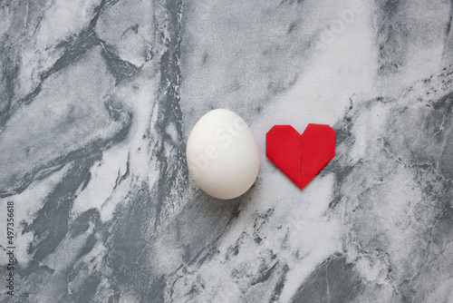 Love egg concept. Egg and paper heart still life. Copy space
