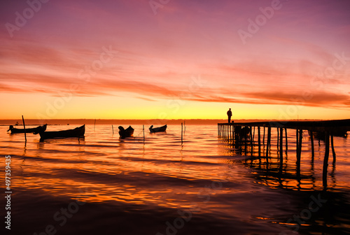 boats at sunrise on the shore of the lake