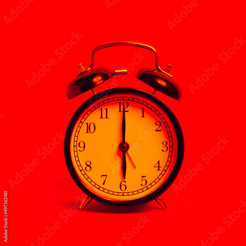 vintage old black alarm clock on red background
