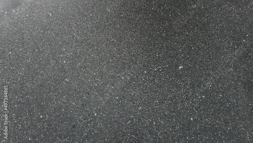 snow falls on black asphalt and melts in the spring wet road. High quality 4k footage