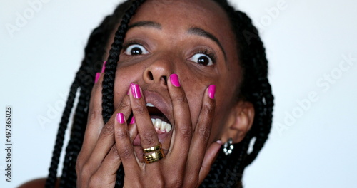 Desperate African woman screaming in HORROR to news, close-up face YELLING and desperation