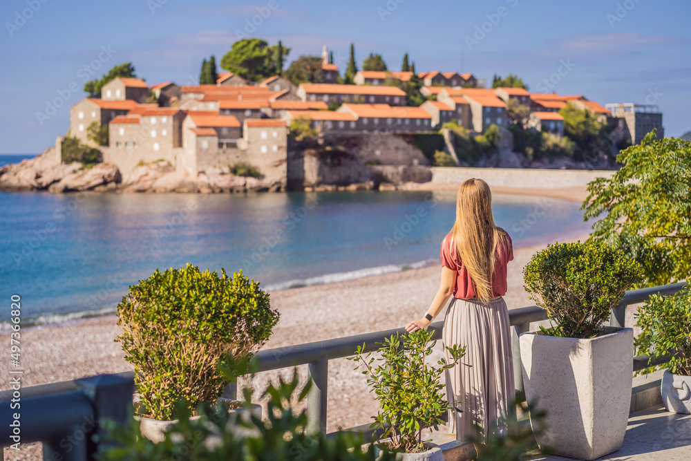 Woman tourist on background of beautiful view of the island of St. Stephen, Sveti Stefan on the Budva Riviera, Budva, Montenegro. Travel to Montenegro concept