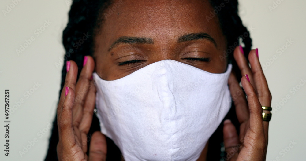 Black Woman removing face mask feeling relief. African person taking off covid-19 face mask, end of pandemic concept