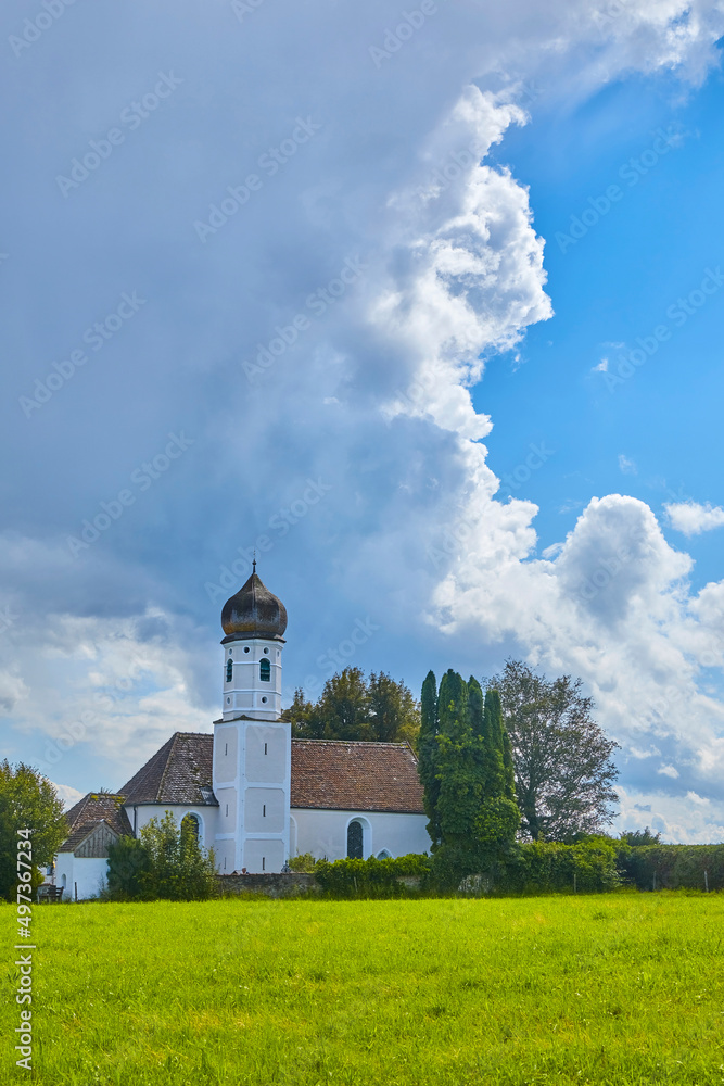 Typische oberbayerische Kapelle mit Gewitterwolken im Hintergrund, Deutschland.