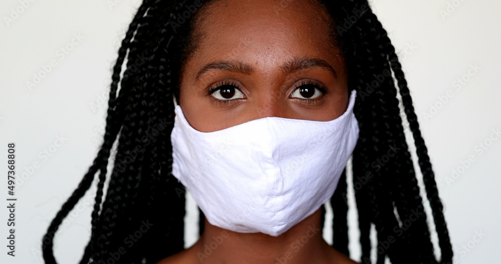 Black girl adjusting covid-19 face mask. African teen wearing mask