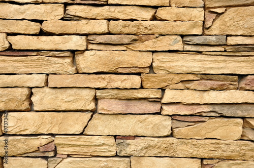 Part of the beige stone wall. Brown rock wall background texture.