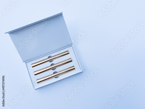 White box with golden syringes on a white background. Soft focus.