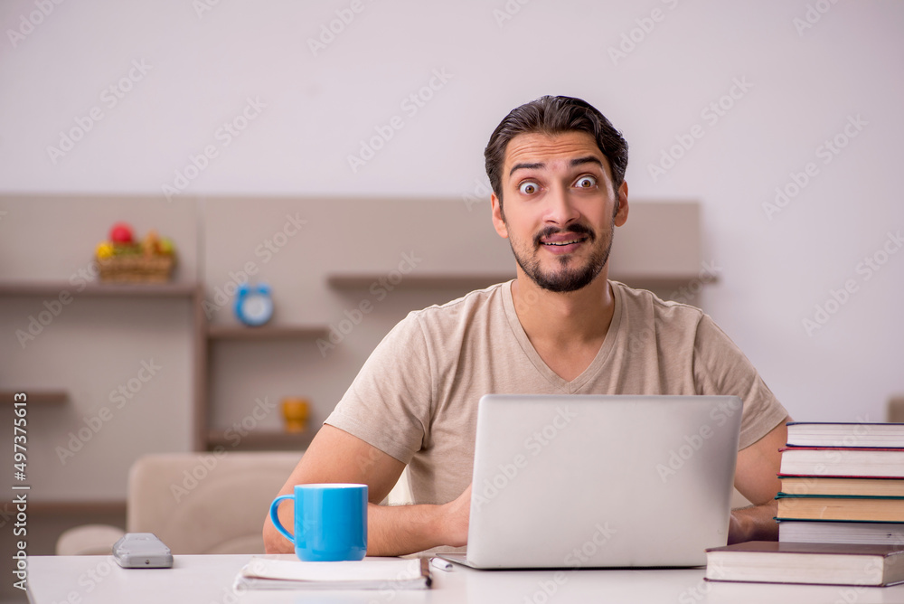 Young male student studying at home during pandemic Young male student studying at home during pandemic
