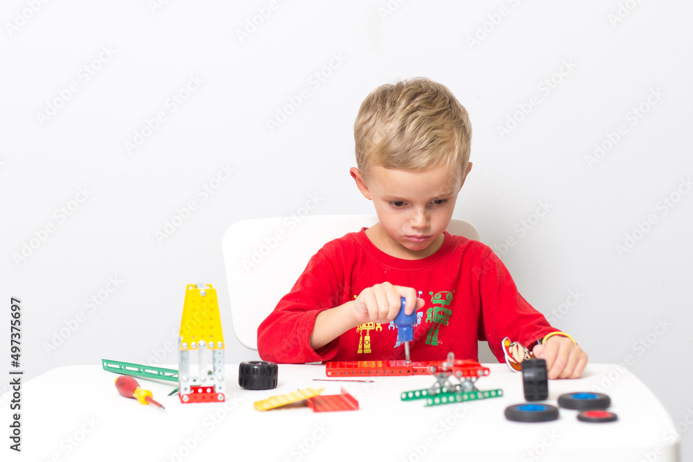 a little boy collects a children's designer from metal. A five-year-old boy collects a constructor a little boy collects a children's designer from metal. A five-year-old boy collects a constructor