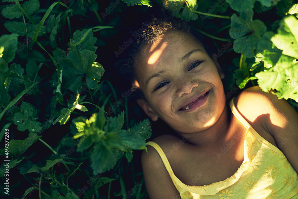 Enjoying summer vacation. Portrait of a smiling girl lying on the grass outside. Enjoying summer vacation. Portrait of a smiling girl lying on the grass outside.