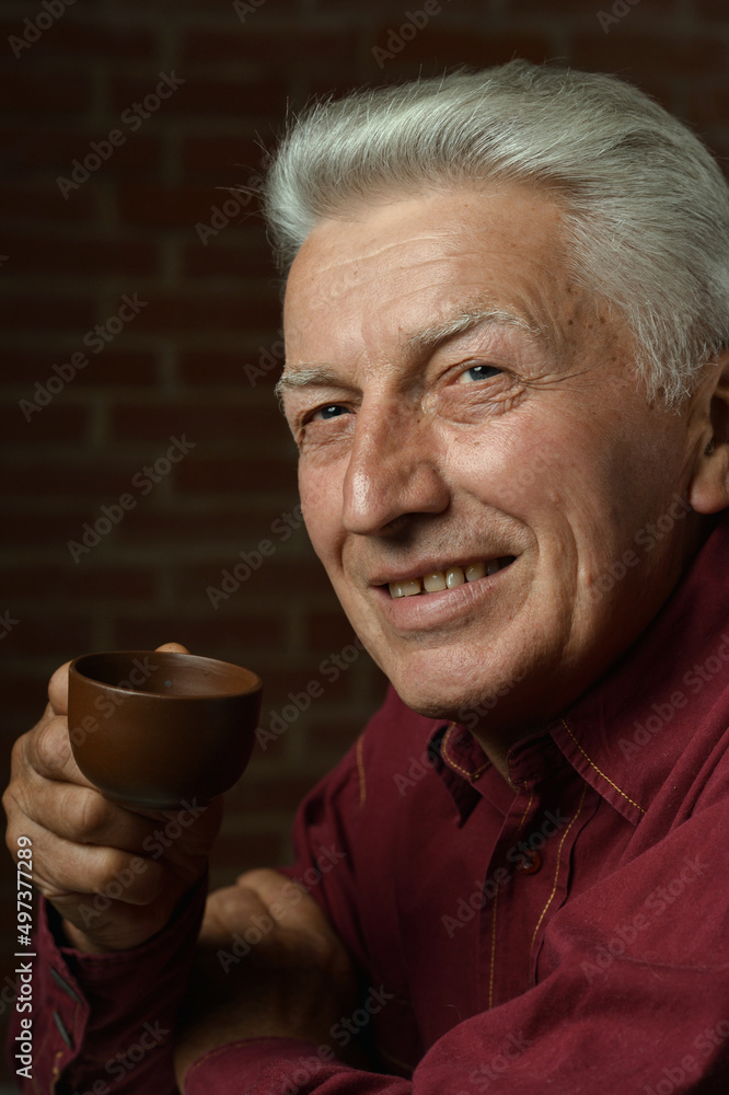 Portrait of smiling senior man drinking coffee at home Portrait of smiling senior man drinking coffee at home
