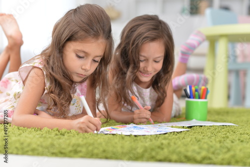 Two cute little girls drawing with pencils photo