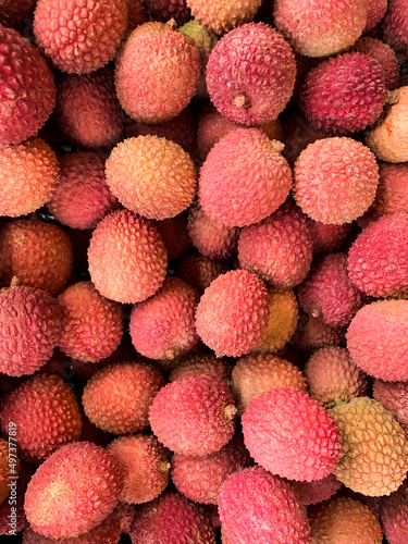 Lychee fruit background. Harvest of litchi fruits. Pink fruit. Texture. Pattern. Lychee exotic fruit background. Full frame picture of harvested litchi fruits or berries. Asian food