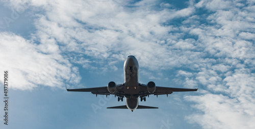 Fotografie Frontal view of modern twin jet engine descending from the clouds