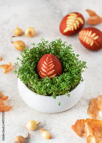 Bilde på lerret Easter egg with pattern leaves in a traditional rustic style in cress nest