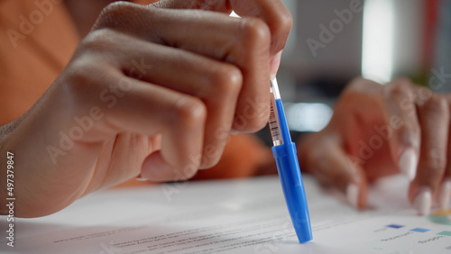 An african professor is checking her students' homework close up