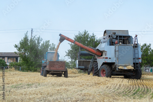 Agricultural machinery collects grain of wheat on the field.The concept of farming and sowing in Ukraine.