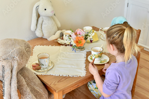 Simple Easter party with plush stuffed bunnies and puppy dog. Child playtime using imagination and serving tea and cookies for afternoon tea. 