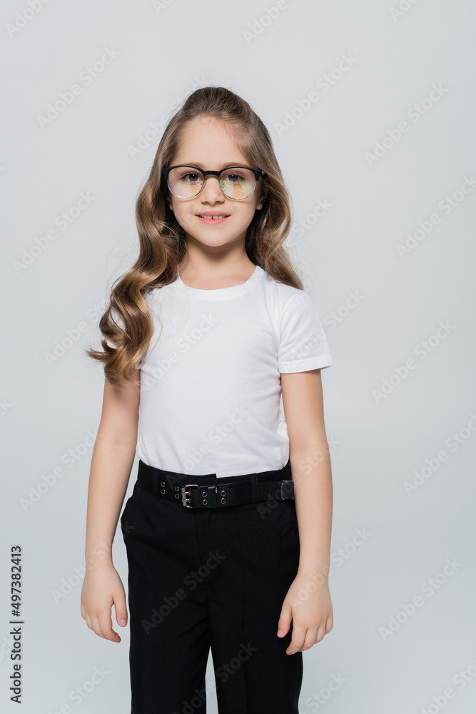 front view of girl in white t-shirt and eyeglasses looking at camera isolated on grey. front view of girl in white t-shirt and eyeglasses looking at camera isolated on grey.