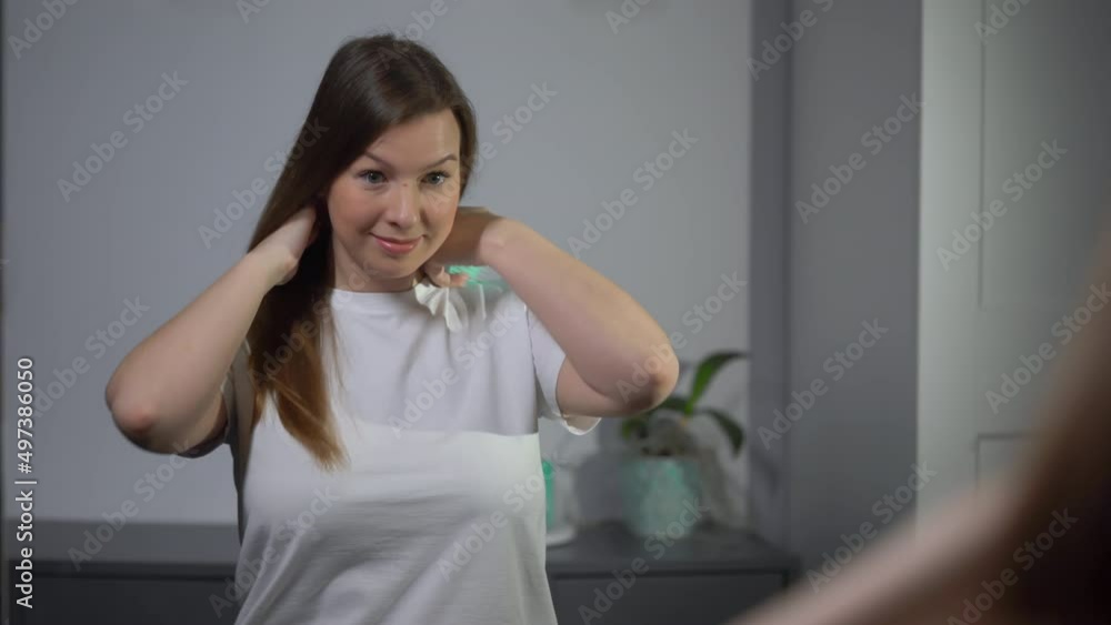 Young woman brushes her hair with a comb. Female is doing and styling her hair. Young woman brushes her hair with a comb. Female is doing and styling her hair.