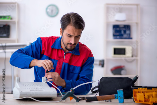 Young male repairman repairing heater