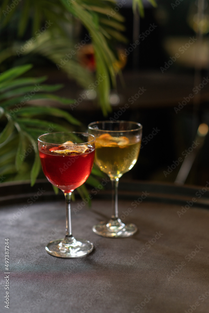 Transparent cocktails in glasses. Red and yellow cocktail at the bar