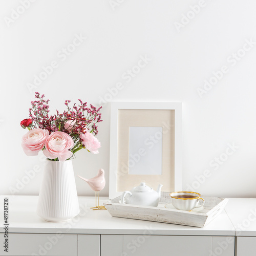 Bouquet of red and pink Persian buttercups on a white table. Scandinavian style. Place for text. Copy space