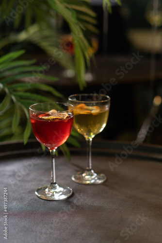 Transparent cocktails in glasses. Red and yellow cocktail at the bar