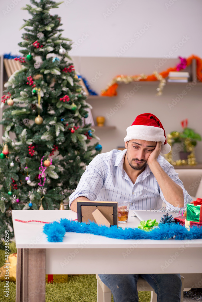 Young man celebrating Christmas at home alone Young man celebrating Christmas at home alone