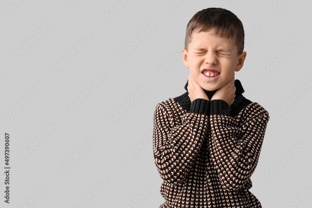 Ill little boy with sore throat on grey background Ill little boy with sore throat on grey background