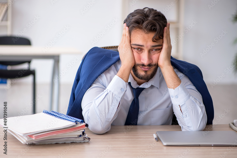 Young male employee extremely tired in the office Young male employee extremely tired in the office