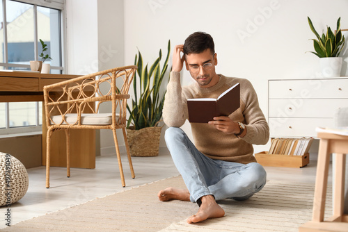 Young barefooted man readin...