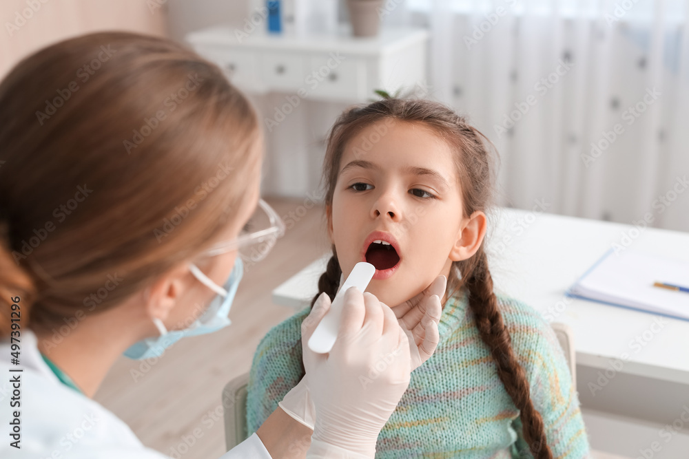 Doctor examining little girl with sore throat in clinic Doctor examining little girl with sore throat in clinic