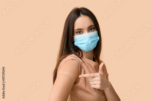 Young woman in mask pointin...