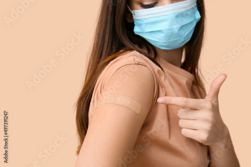 Young woman in mask pointin...